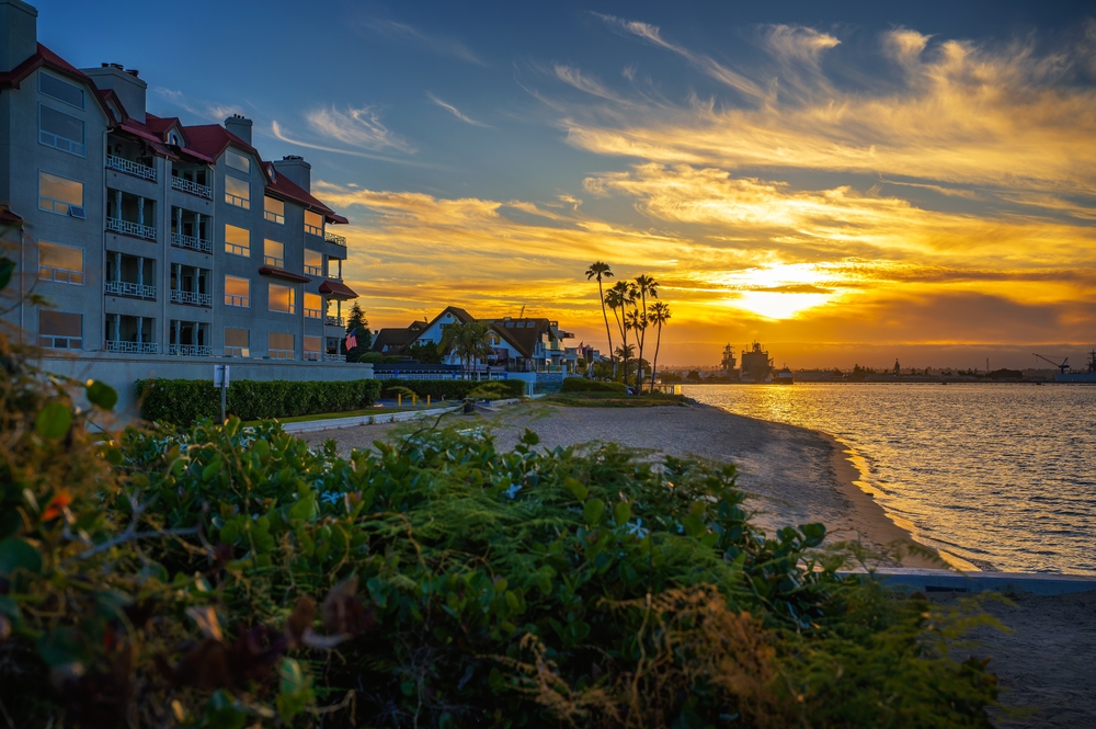 Scenic San Diego waterfront at sunset featuring coastal homes and palm trees, highlighting the local neighborhoods where JP Buys SD purchases properties - JP Buys SD